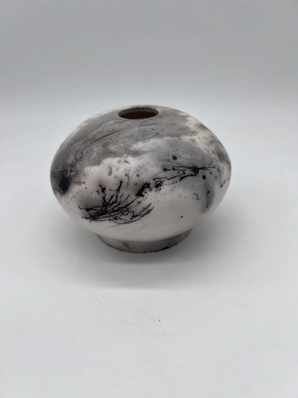 "Raku Pot with Heron Feathers" by Dane Miller