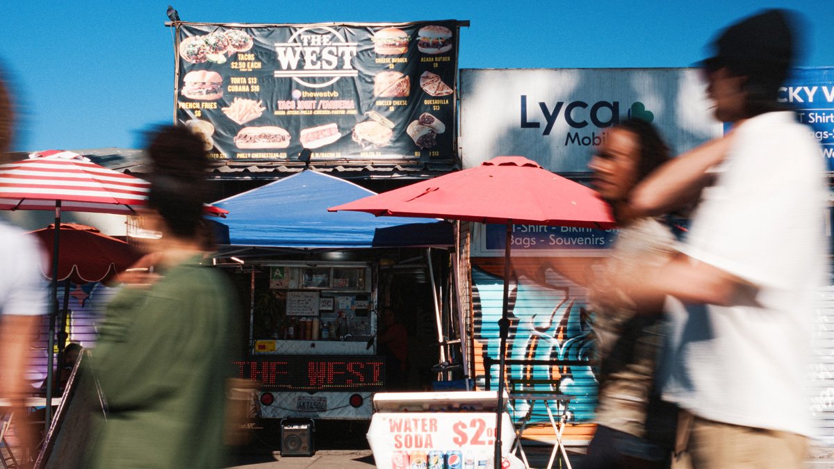 motion blurred people walk past venice beach boardwalk shots