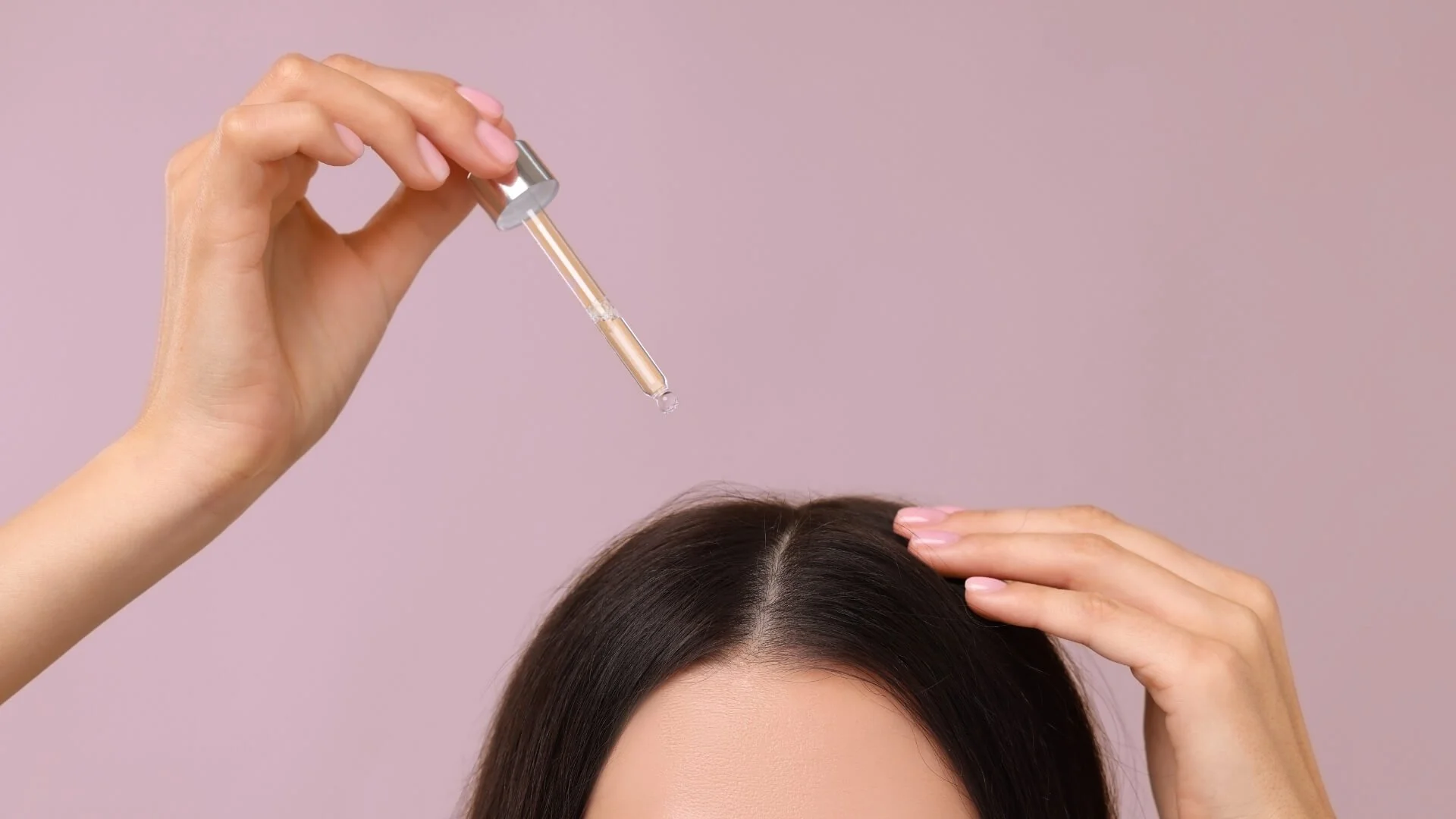 Woman applying hair serum for growth