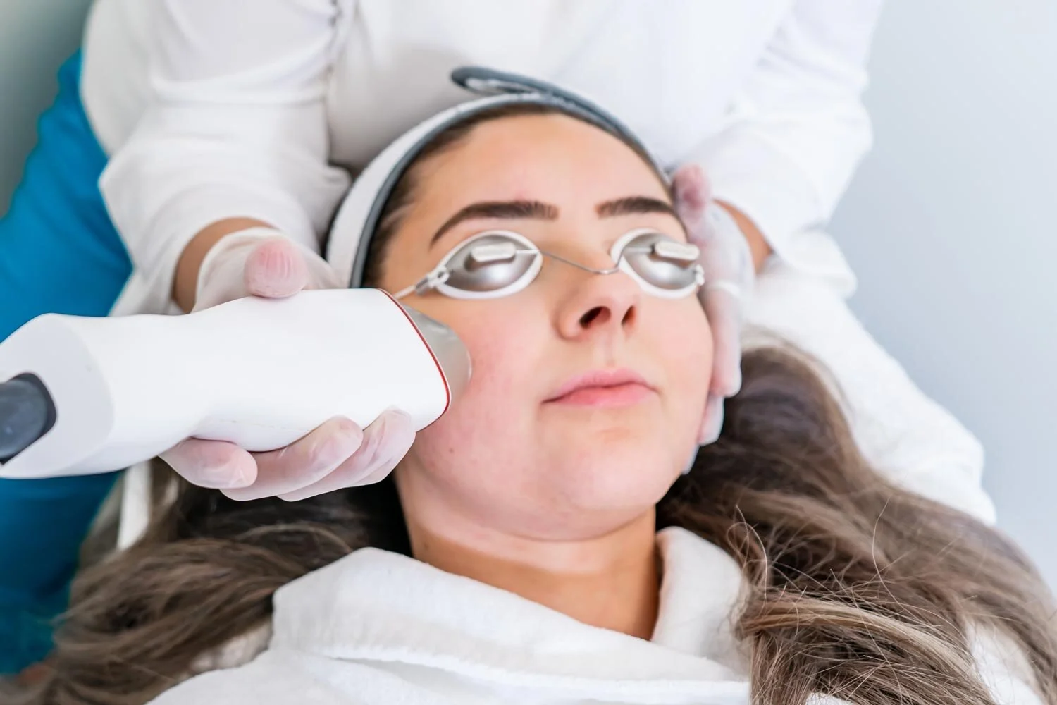 Woman receiving Microneedling treatment on her face.
