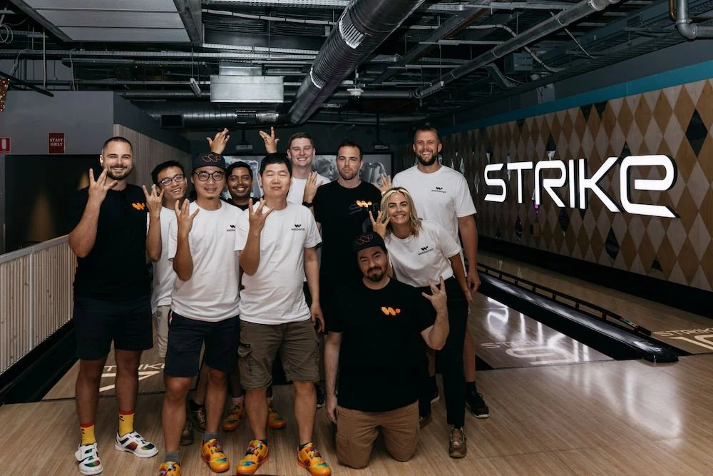 The Webbernet team making a W sign with their hands, at Strike Bowling