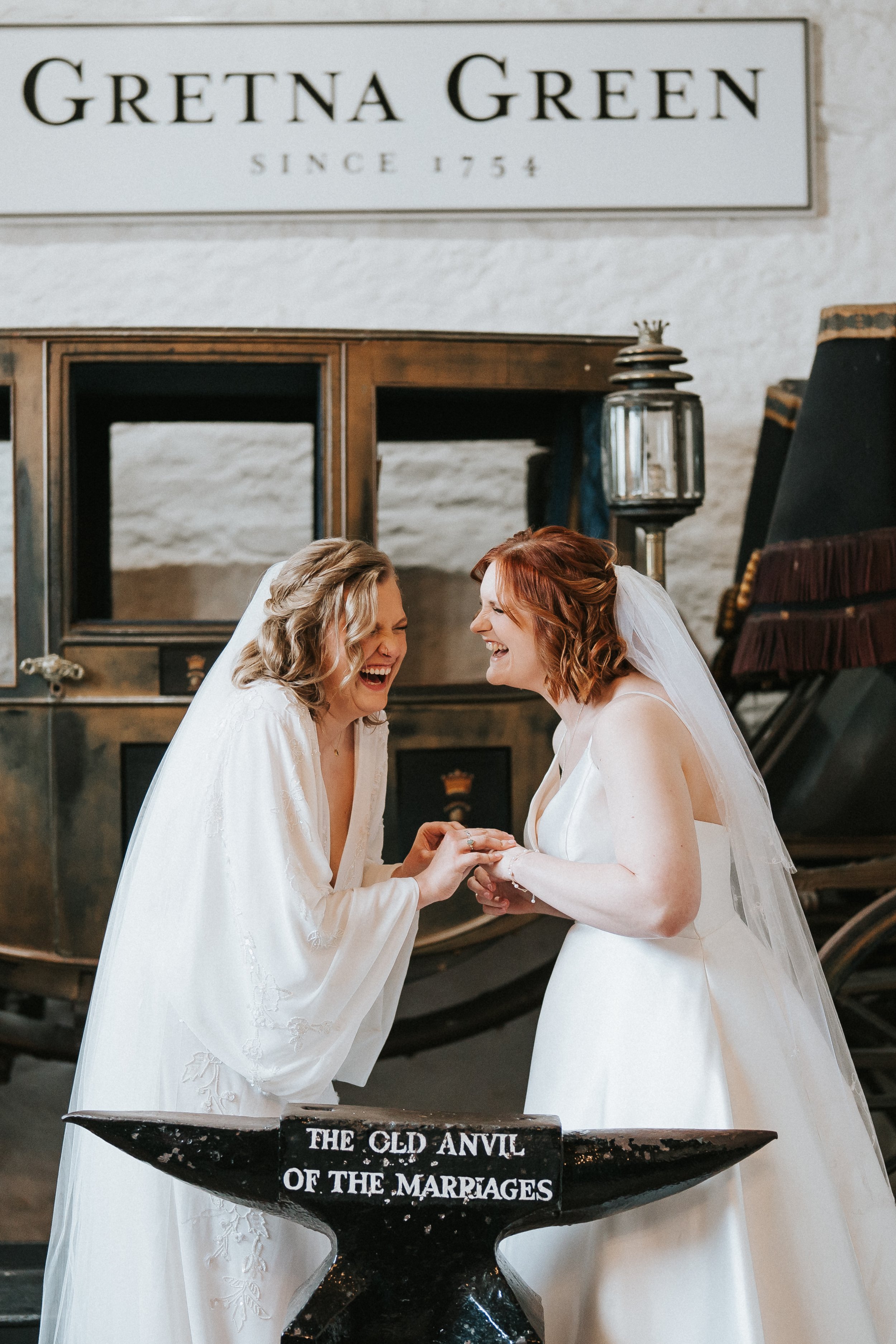 Two Brides in Gretna Green exchanging rings both wearing dresses and veils