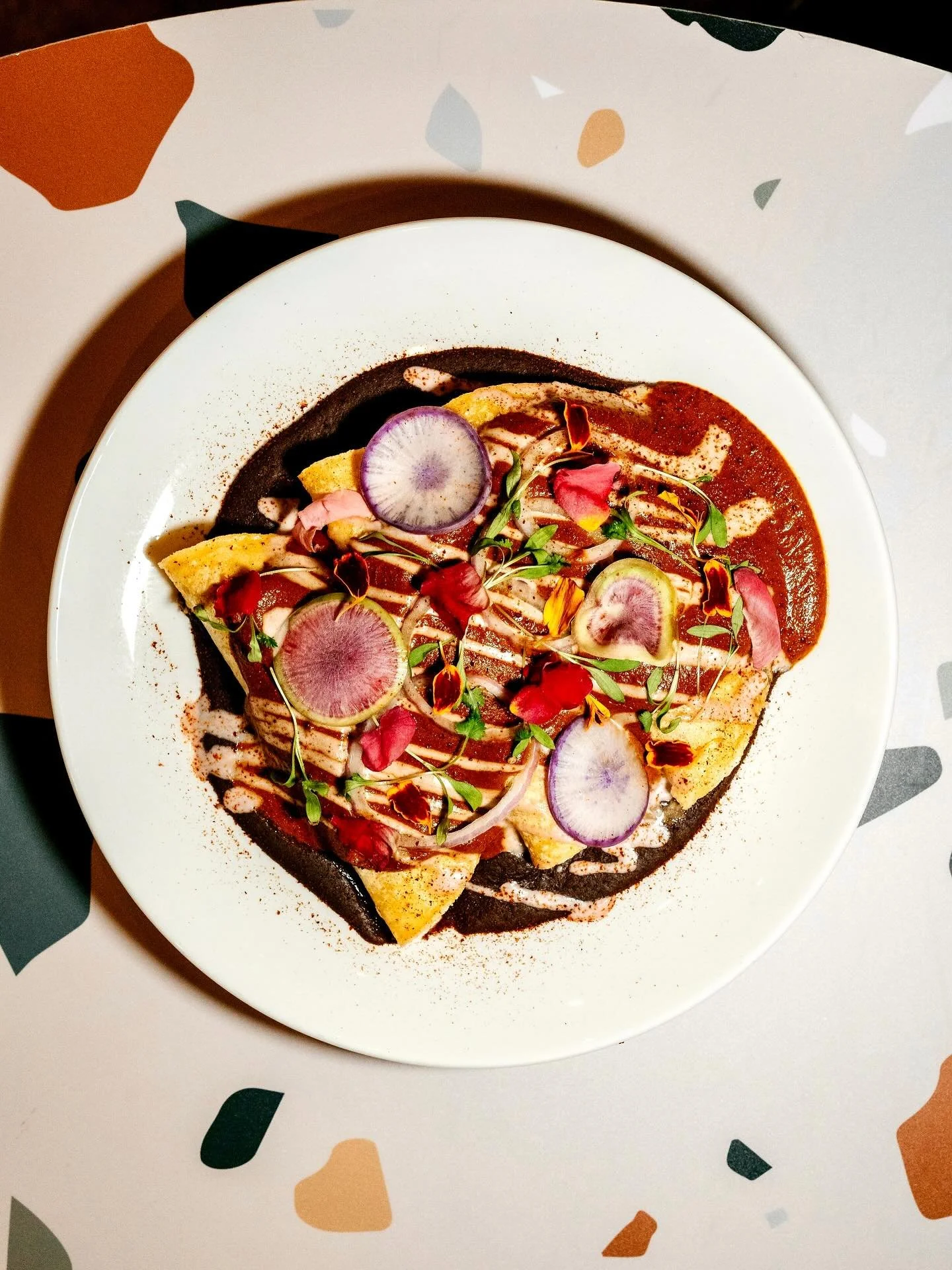 Mole rojo is back on our seasonal enmoladas! This is one of our most treasured plates because of the amount of hands involved in bringing it to life. Thin corn tortillas by @molinotortillasatl filled with rotating veggies from our farmers sit on a be
