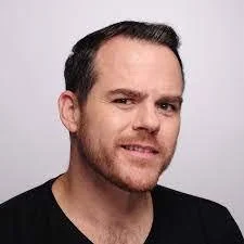 Photo of Joshua Haynes in a black t shirt.