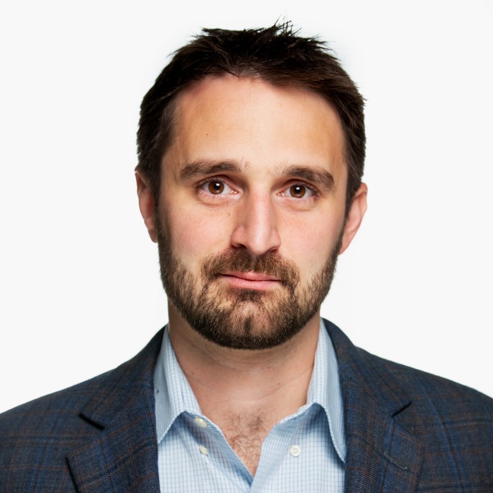 Photo of Matt Angle in a blue shirt and blue jacket.