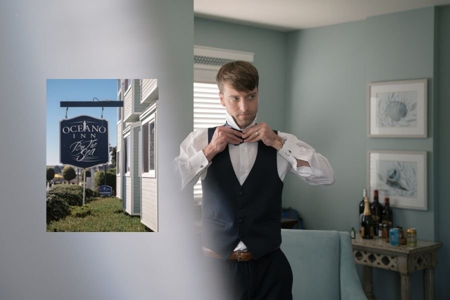 Man adjusting a bow tie in a calm, elegant room with blue walls and framed seashell art. A small inset shows the Oceano Inn sign outside.