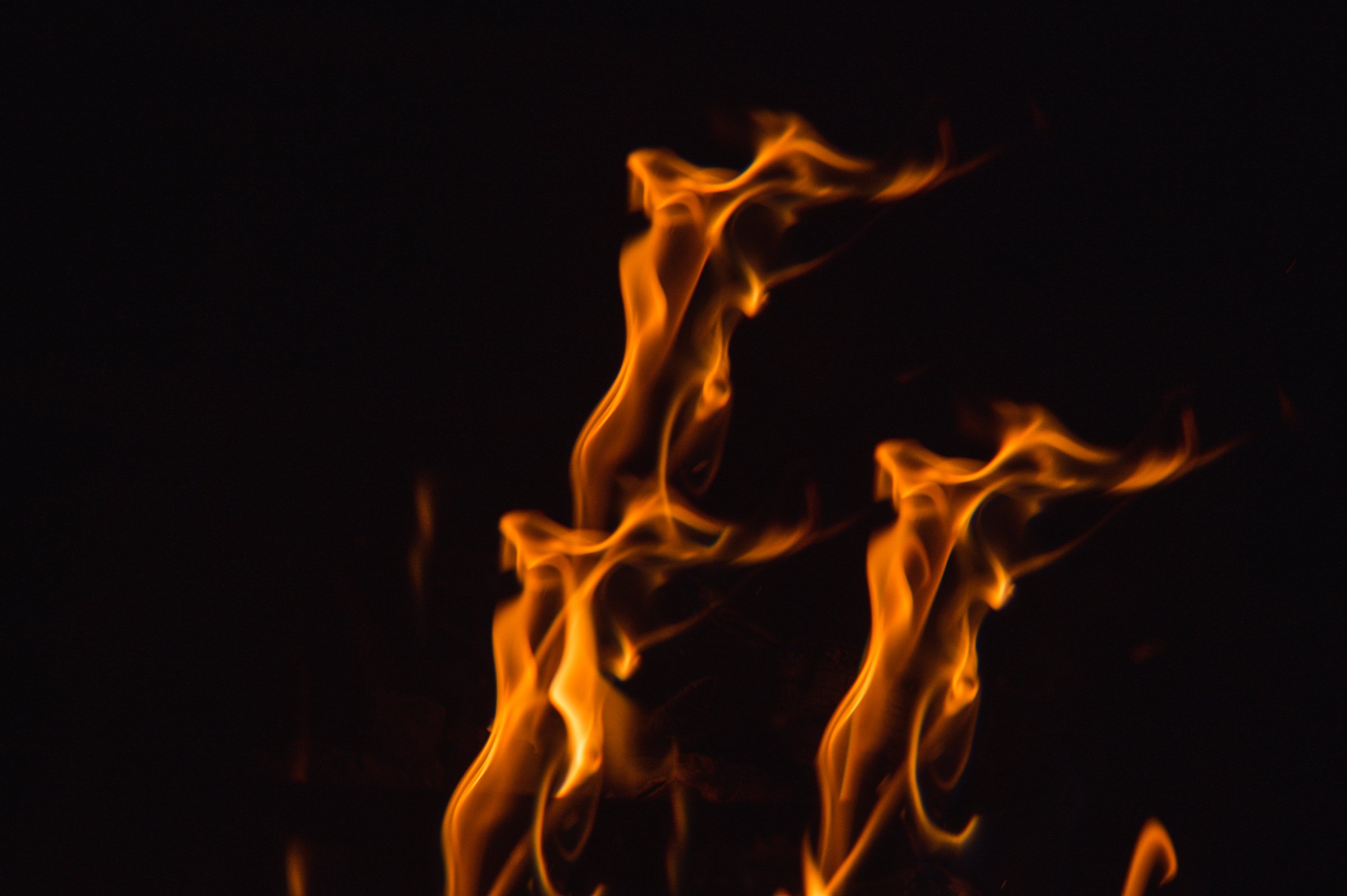 Orange and yellow flames flickering against a dark background in a vertical pattern.