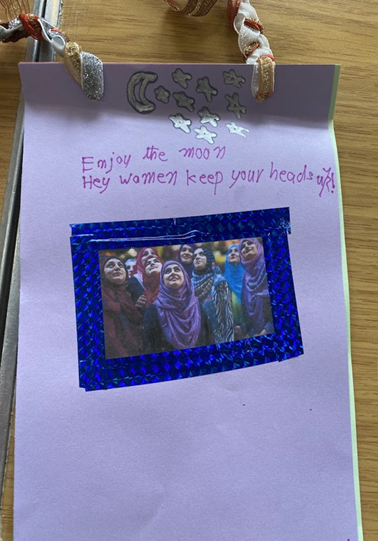 A zine page evoking female empowerment with an image of women looking upwards