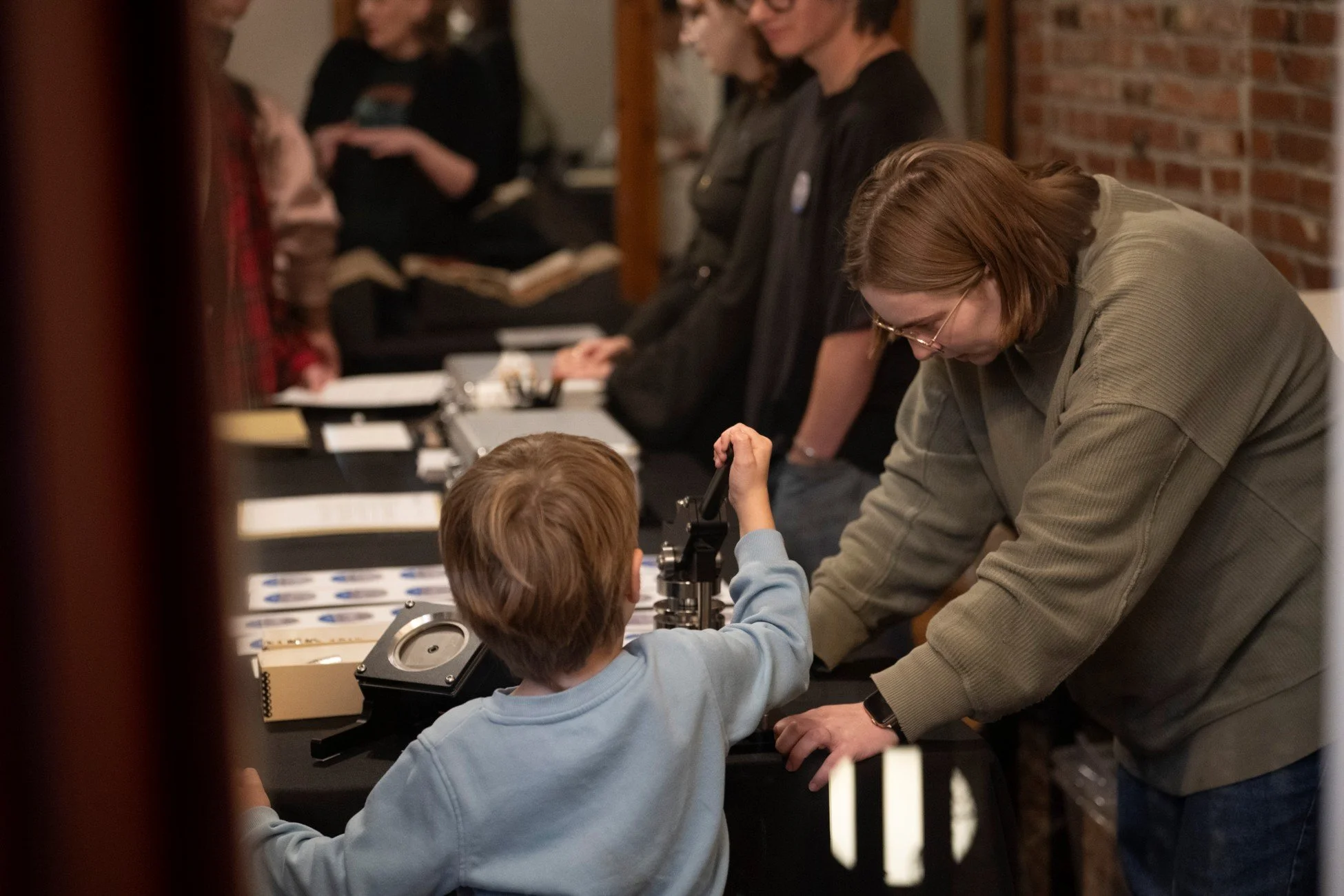 Children engaging in button-making. Photo courtesy of Kevin McCarty, KU Libraries Office of Communication & Advancement