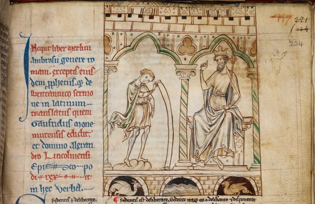 Manuscript image from Prophecies of Merlin which shows a young boy holding a long scroll standing before a king seated on a throne