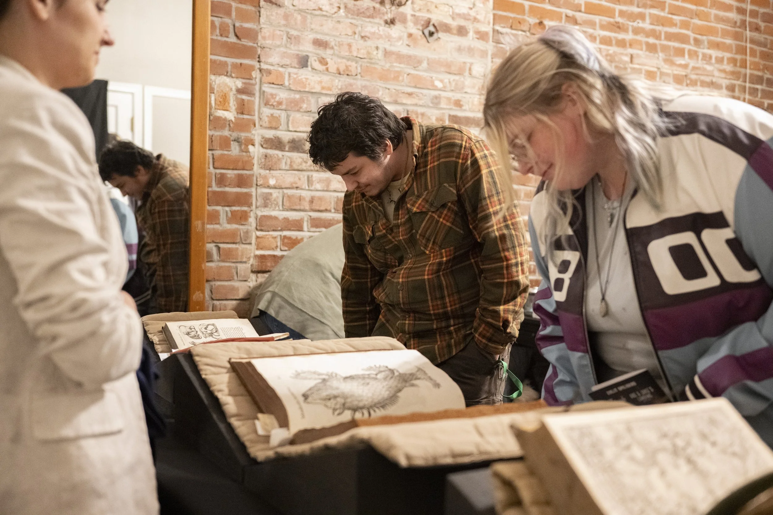 Visitors look at a displayed selection of printed libri monstrorum, or ‘Books of Monsters.’ Photo courtesy of Kevin McCarty, KU Libraries Office of Communication & Advancement