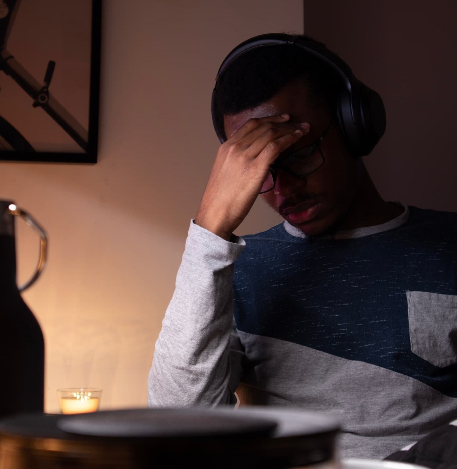 man with headphones on and hand over his face