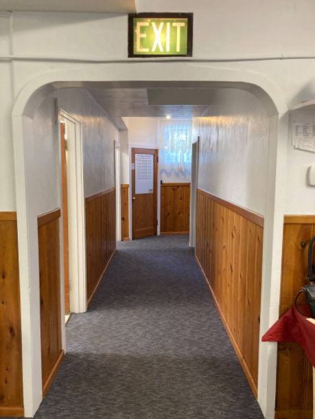 The hallway on the lower floor connects to the kitchen (through doors on the left) and upper floor.