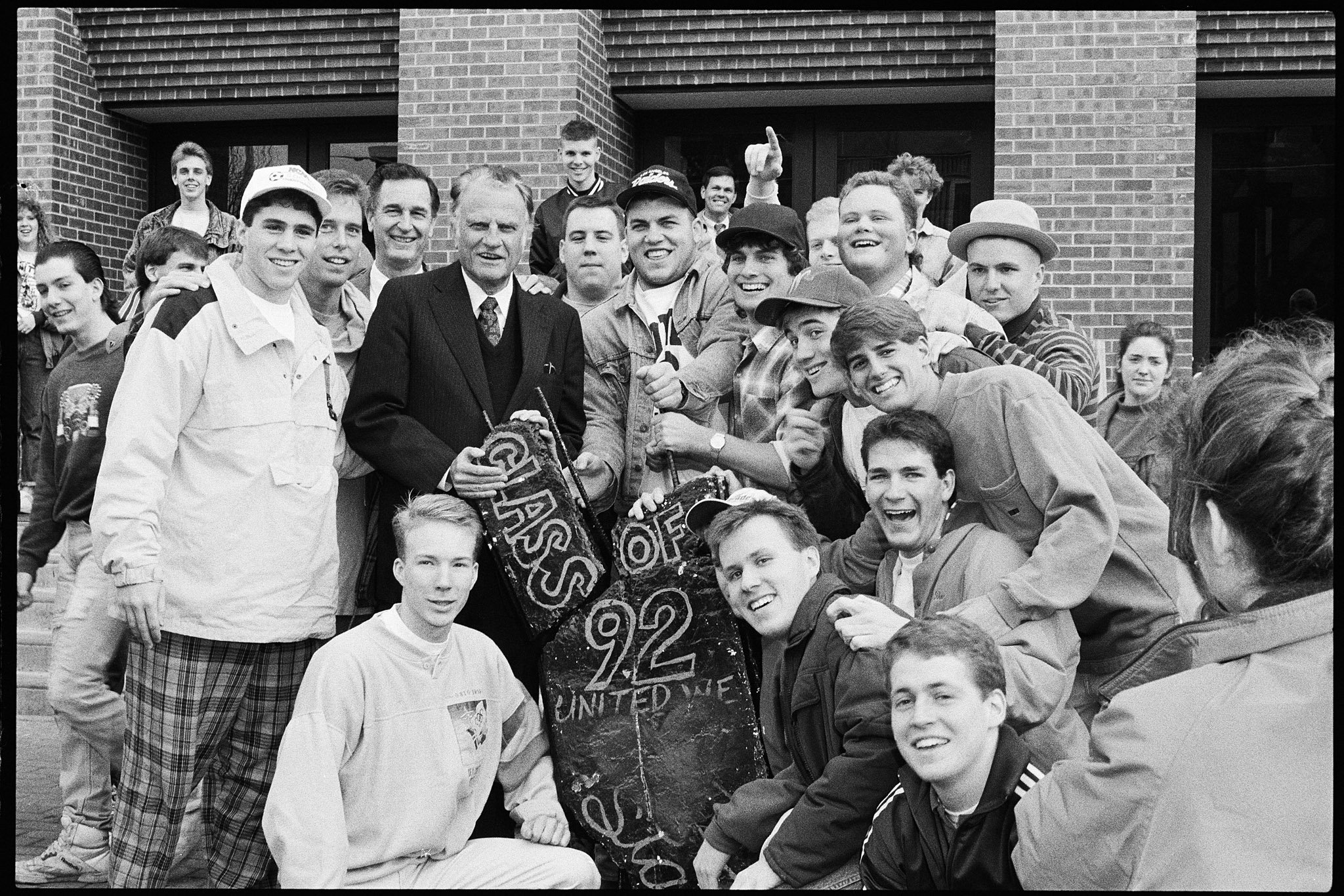Billy Graham visit to campus, posing with members of the junior class with the senior bench, February 9, 1991