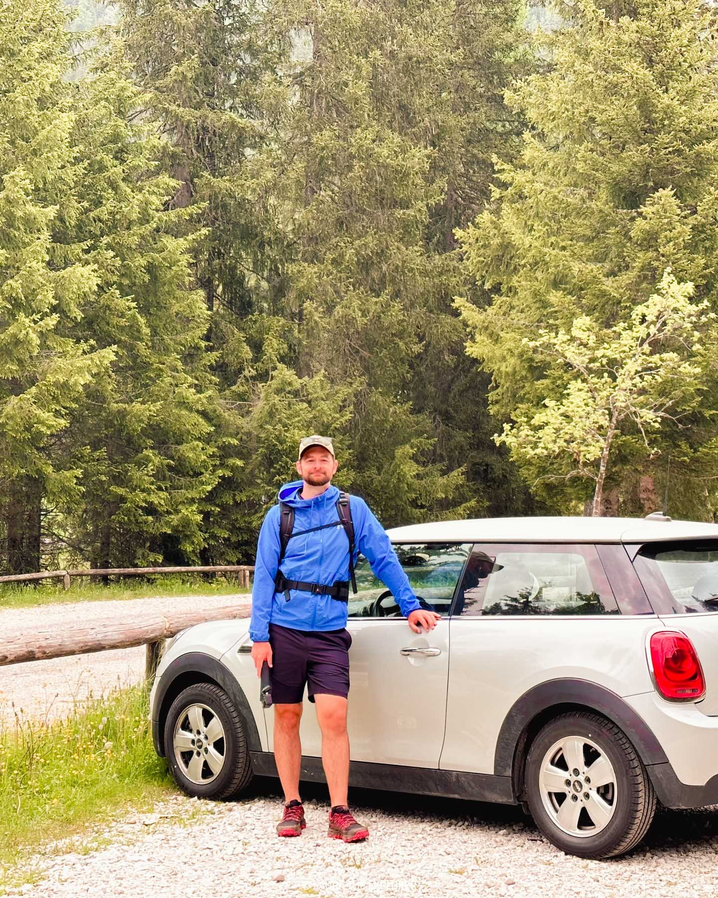 man with his rental car in the dolomites