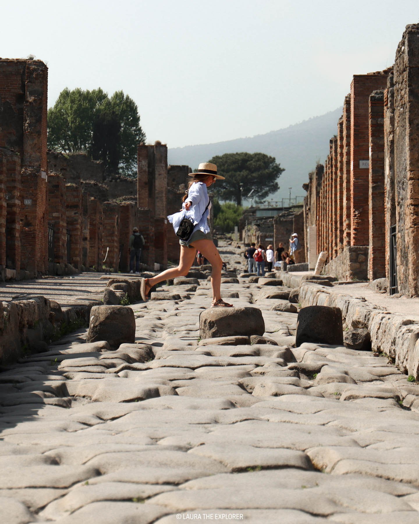 laura the explorer jumping the old cobblestone streets of pompei