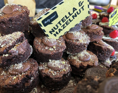 Chocolate cookies topped with powdered sugar and a sign that says "Nutella & Hazelnut"