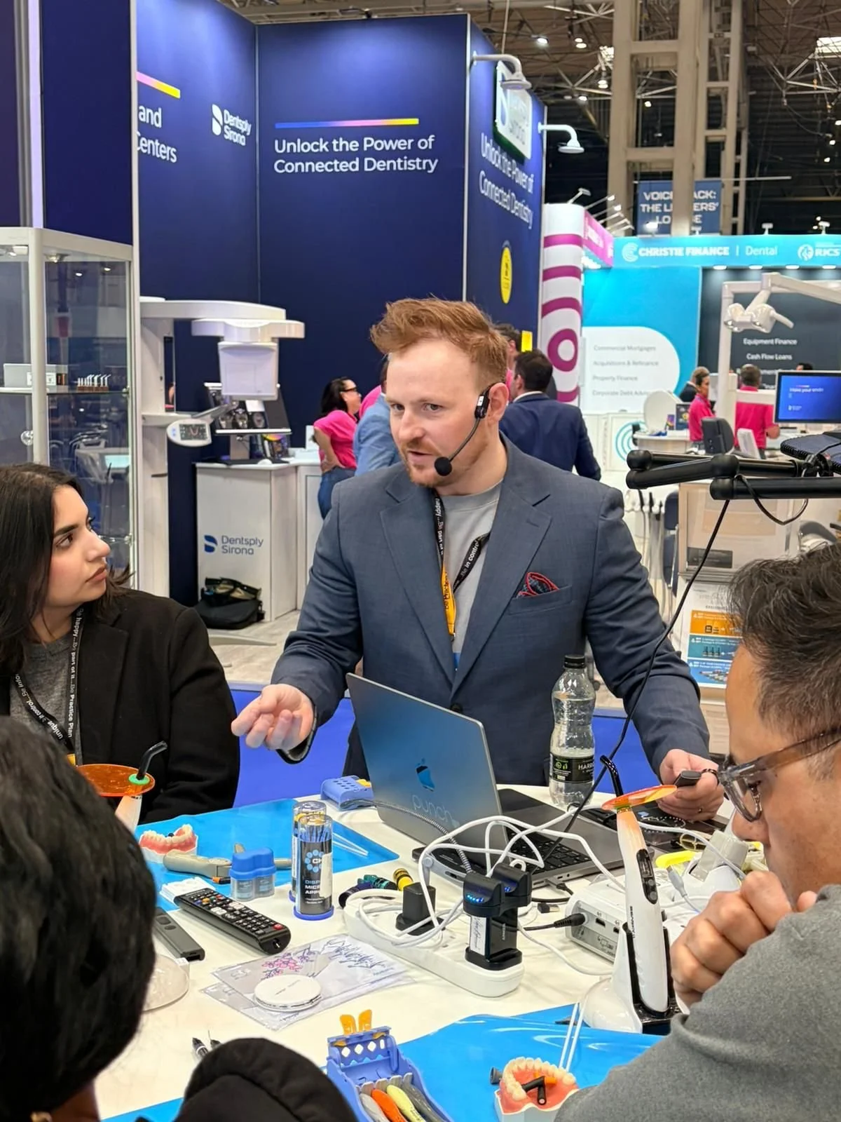 Dentist demonstrating rubber dam isolation during a hands-on dental course, teaching restorative dentistry, matrix systems, and adhesive techniques.