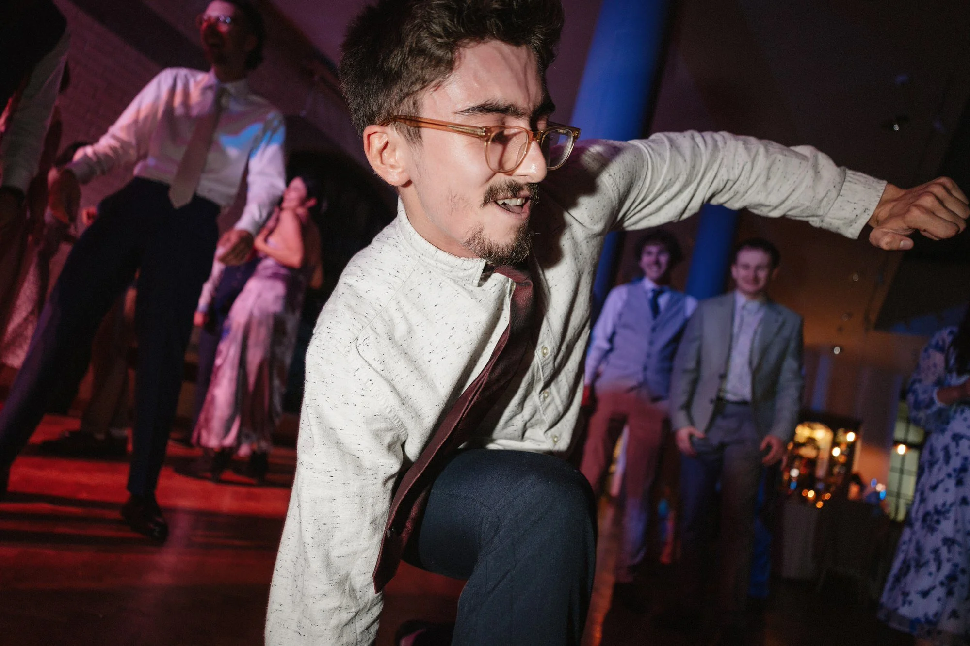 A guest dancing low to the floor in the party lighting while others watch, The Pumping House, Ollerton