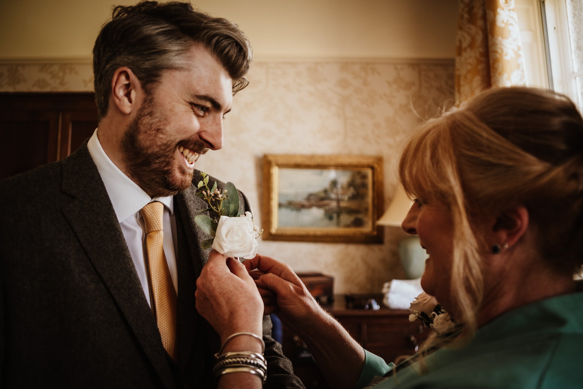 Mother of the groom puts on a buttonhole
