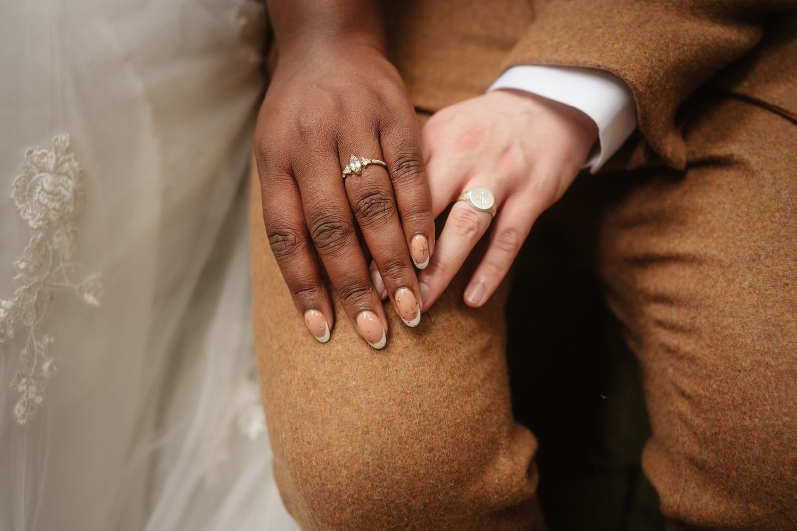 Close-up of the bride and groom holding hands
