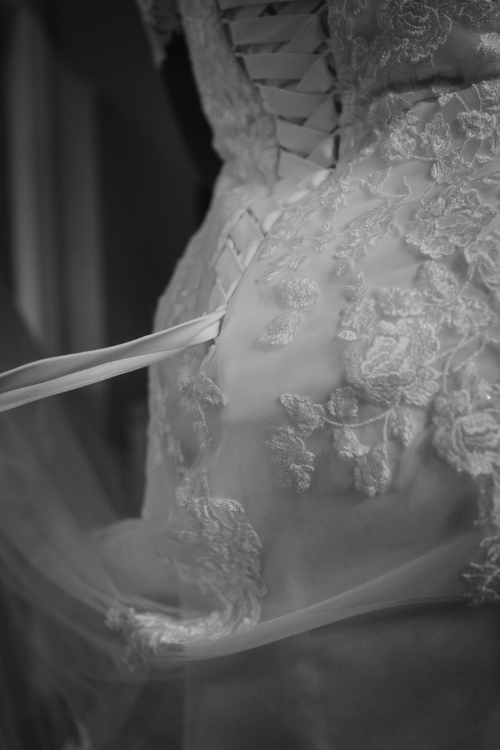  Black and white close-up of the lace-up back of the bride's dress 