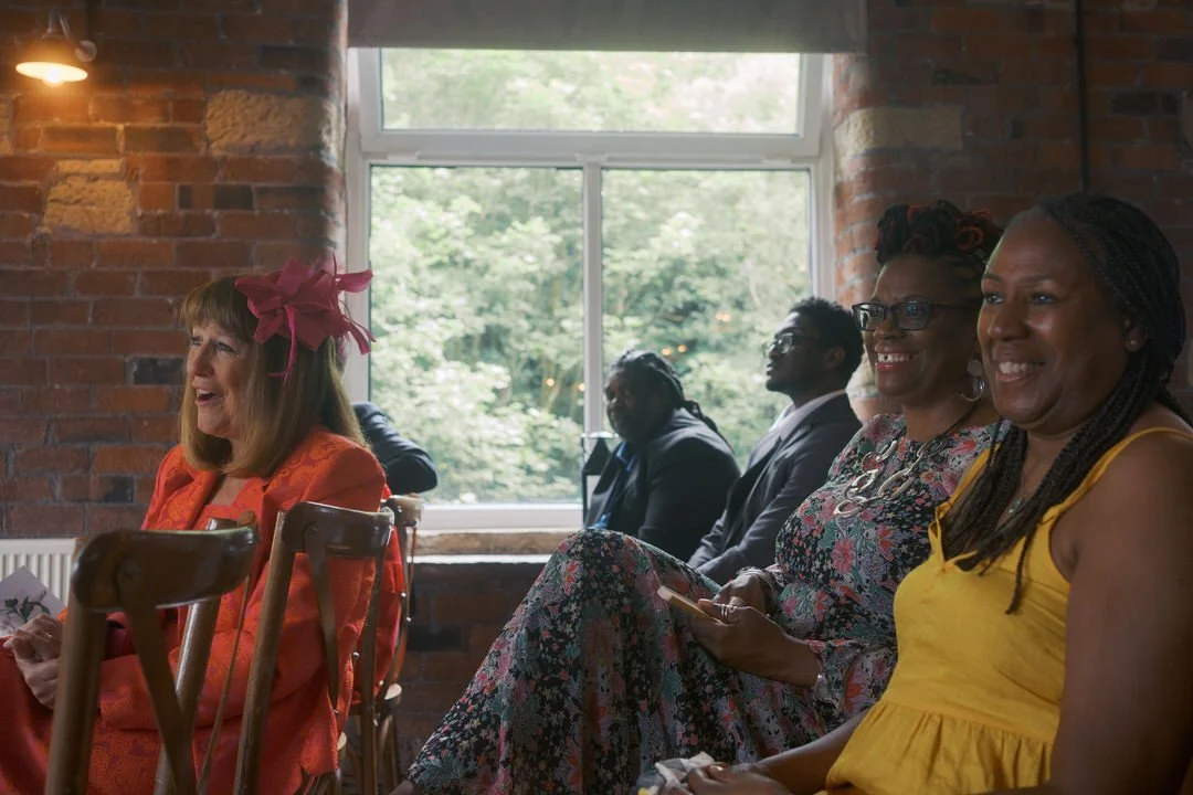  Guests smiling during the wedding ceremony at Bowers Mill 