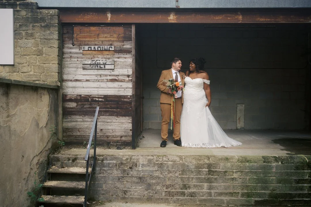  The bride and groom laughing in the old loading dock at Bowers Mill 