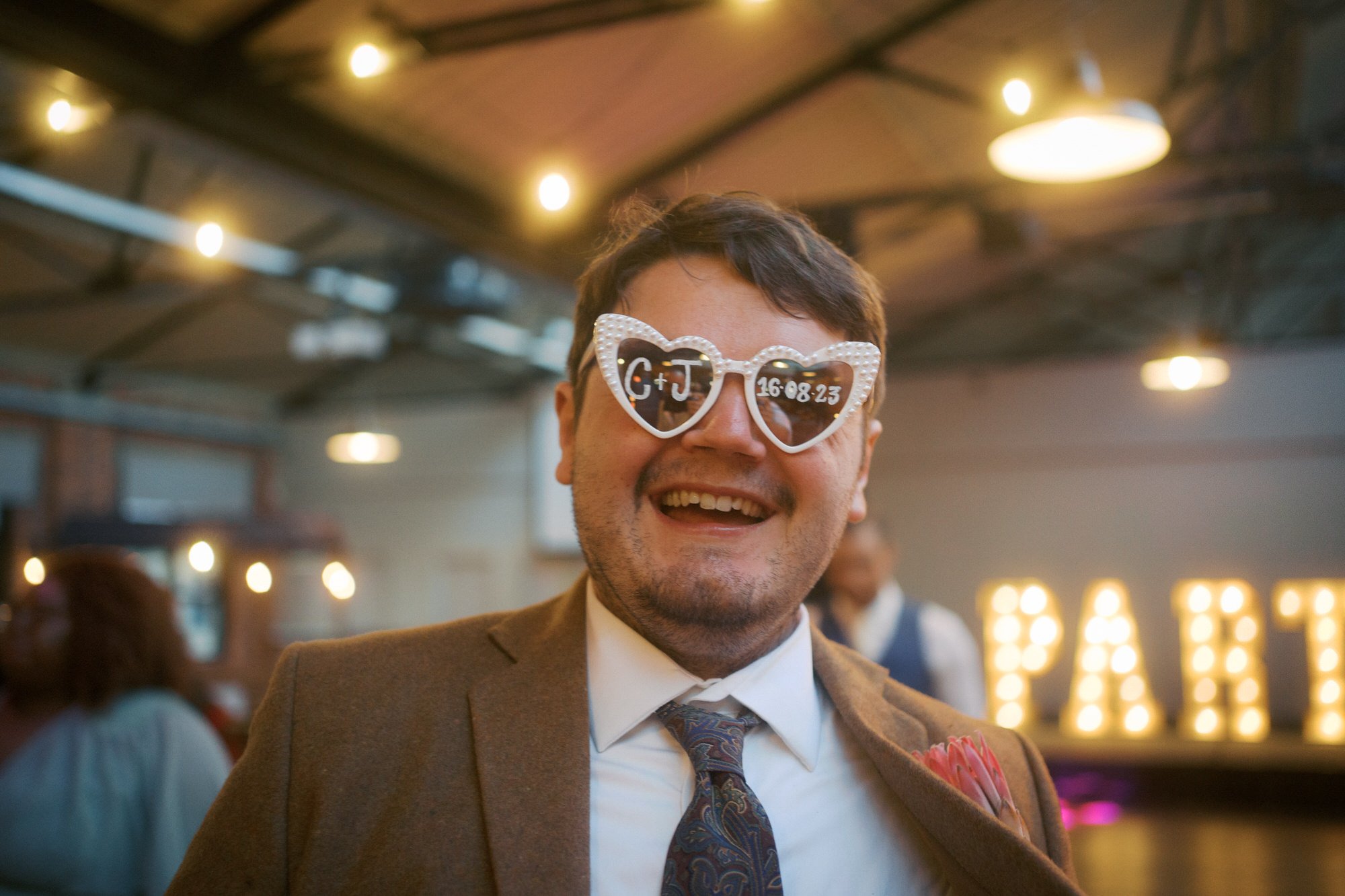  The groom in heart-shaped sunglasses printed with the wedding date 
