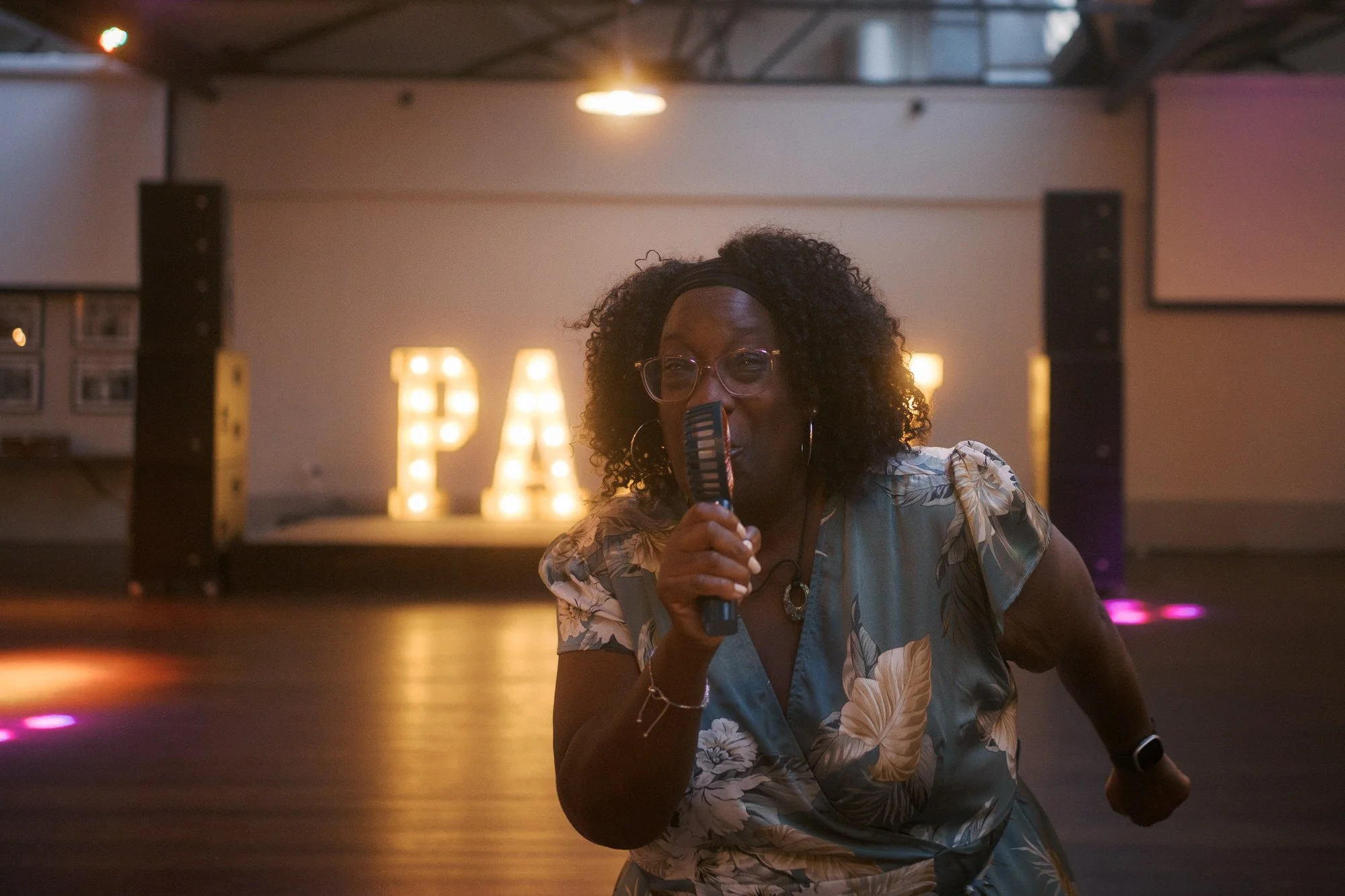  A guest singing into a handheld fan on the dance floor 