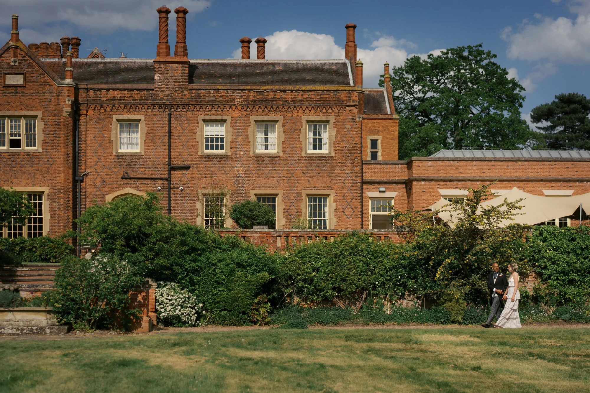 A couple small against the long red-brick front of Hodsock Priory, Nottinghamshire