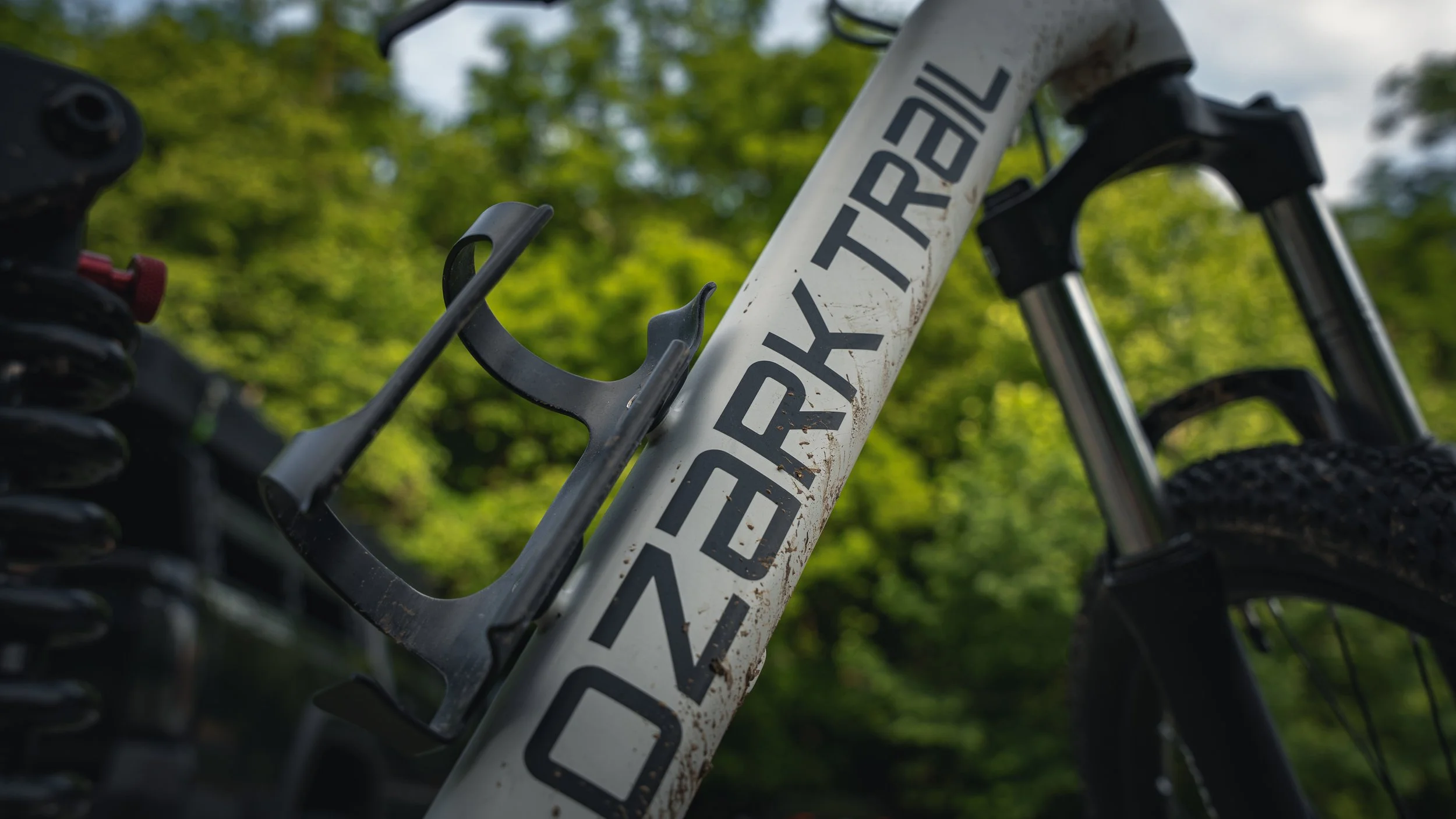 Ozark Trail FS.2 Slalom mountain bike frame with mud. aluminum mountain bike bottle holder mounted to the frame.