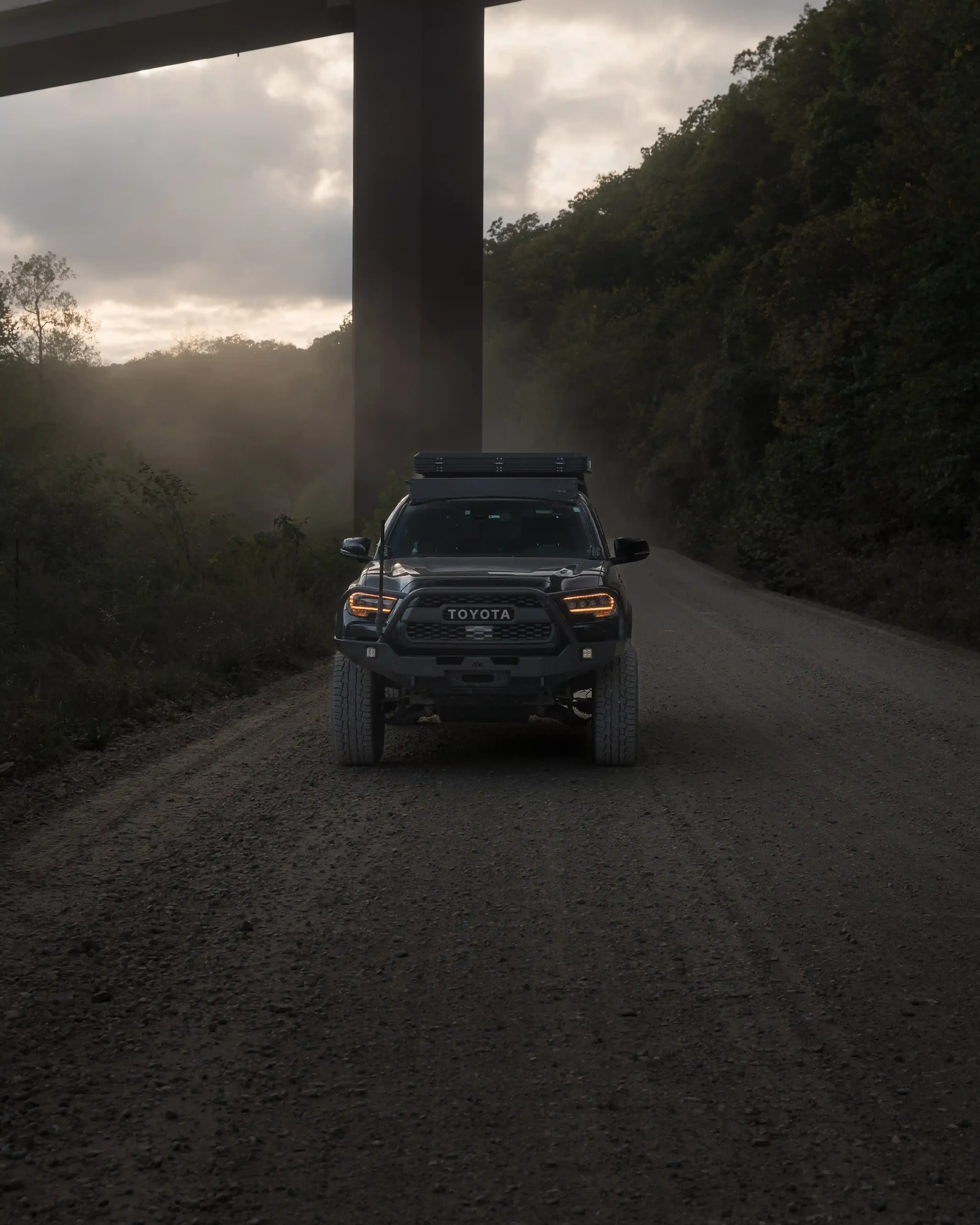 Toyota Tacoma overland build on dirt road on cloudy day