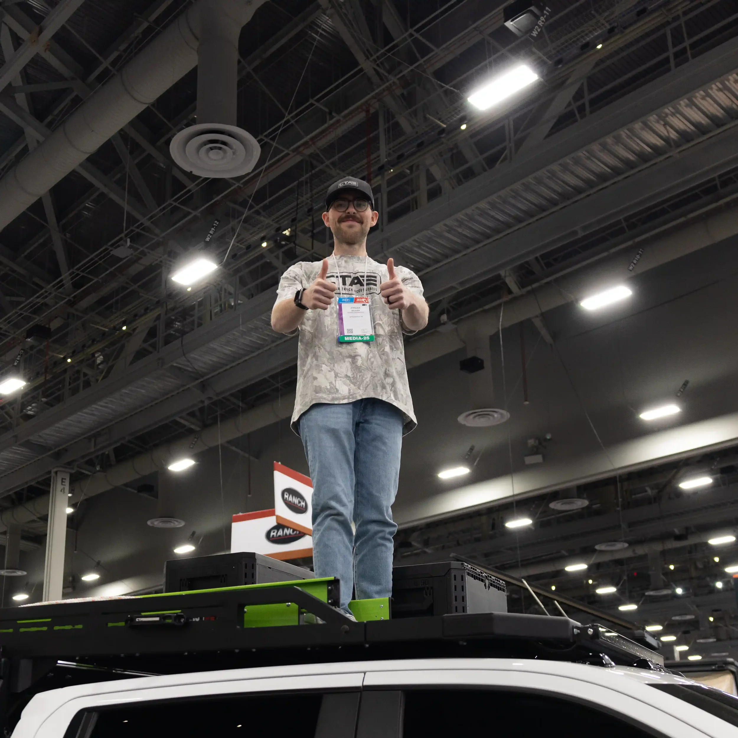 Jordan Weaver standing on top of a truck at SEMA show