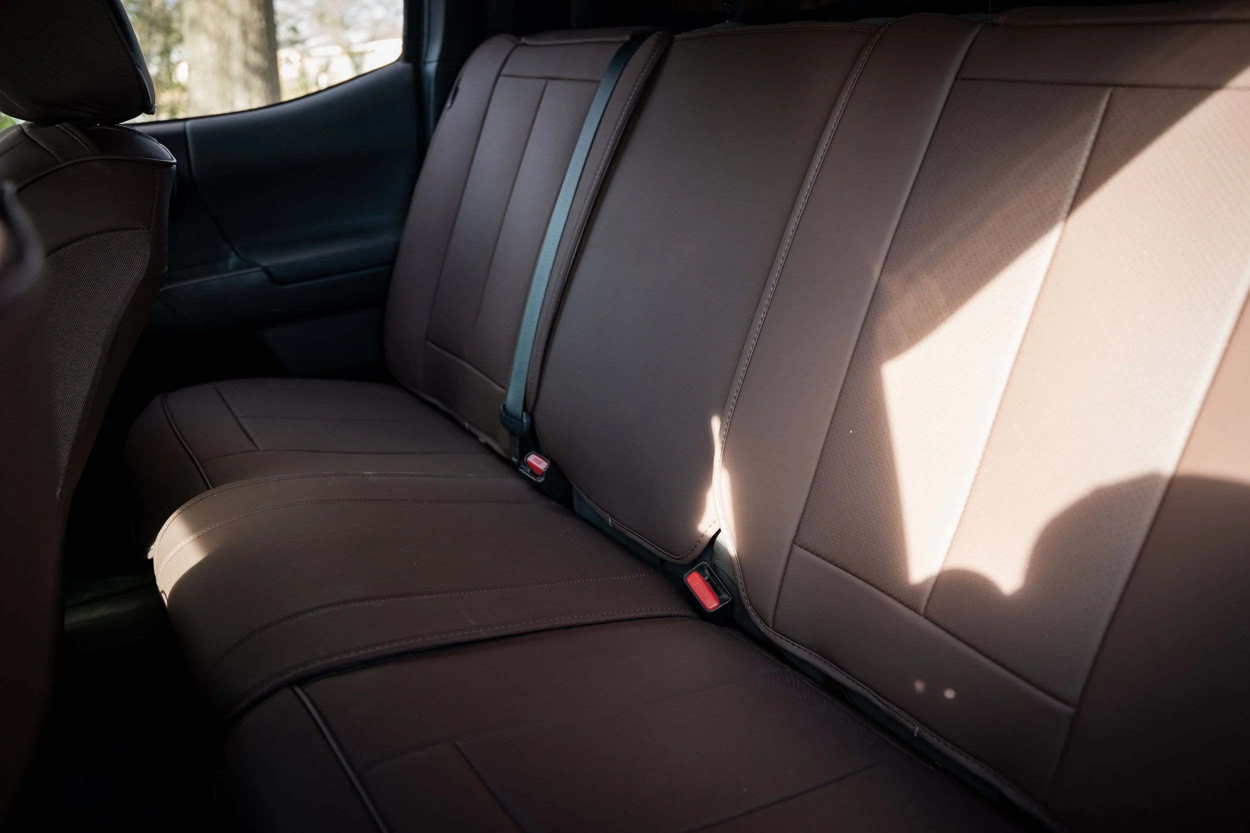 Rear bench seat in Toyota Tacoma with brown Coverland seat covers.