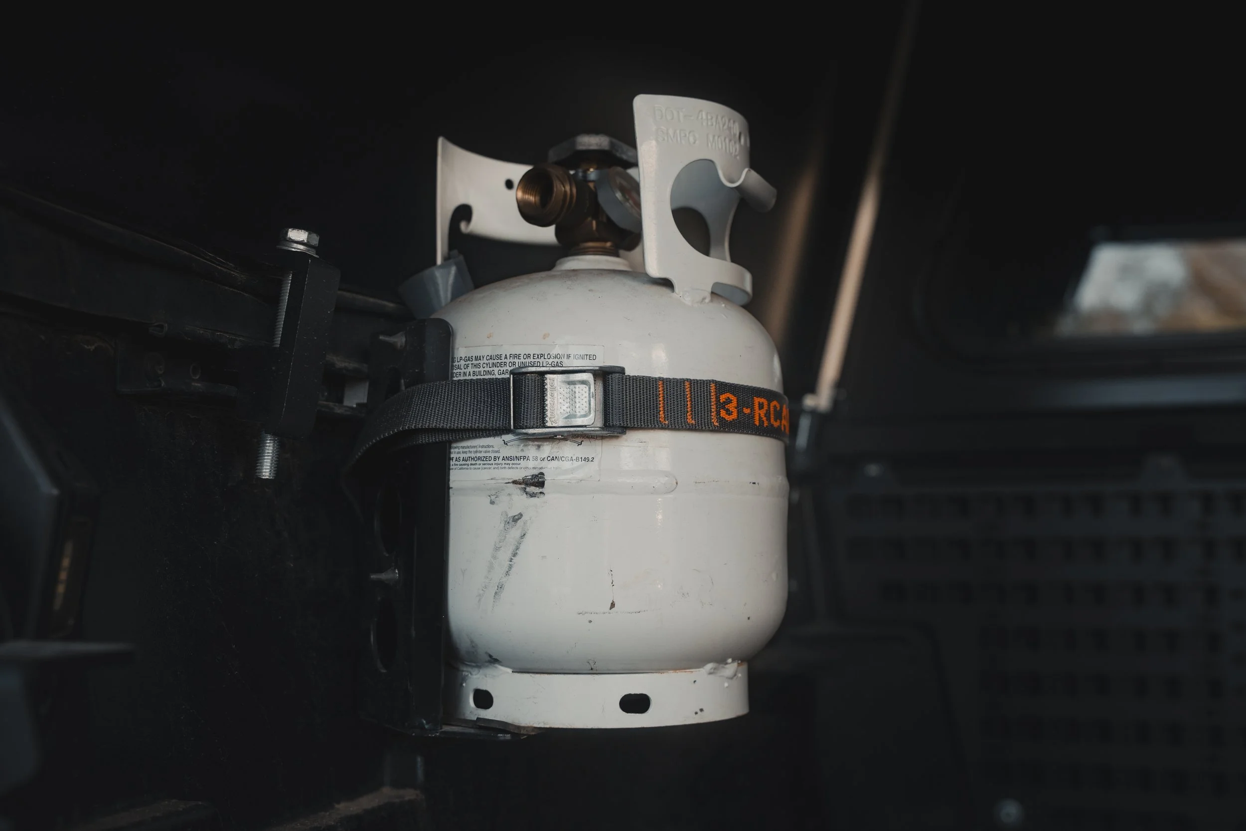 Propane tank mounted on Tacoma bed rail secured with Rollercam strap.