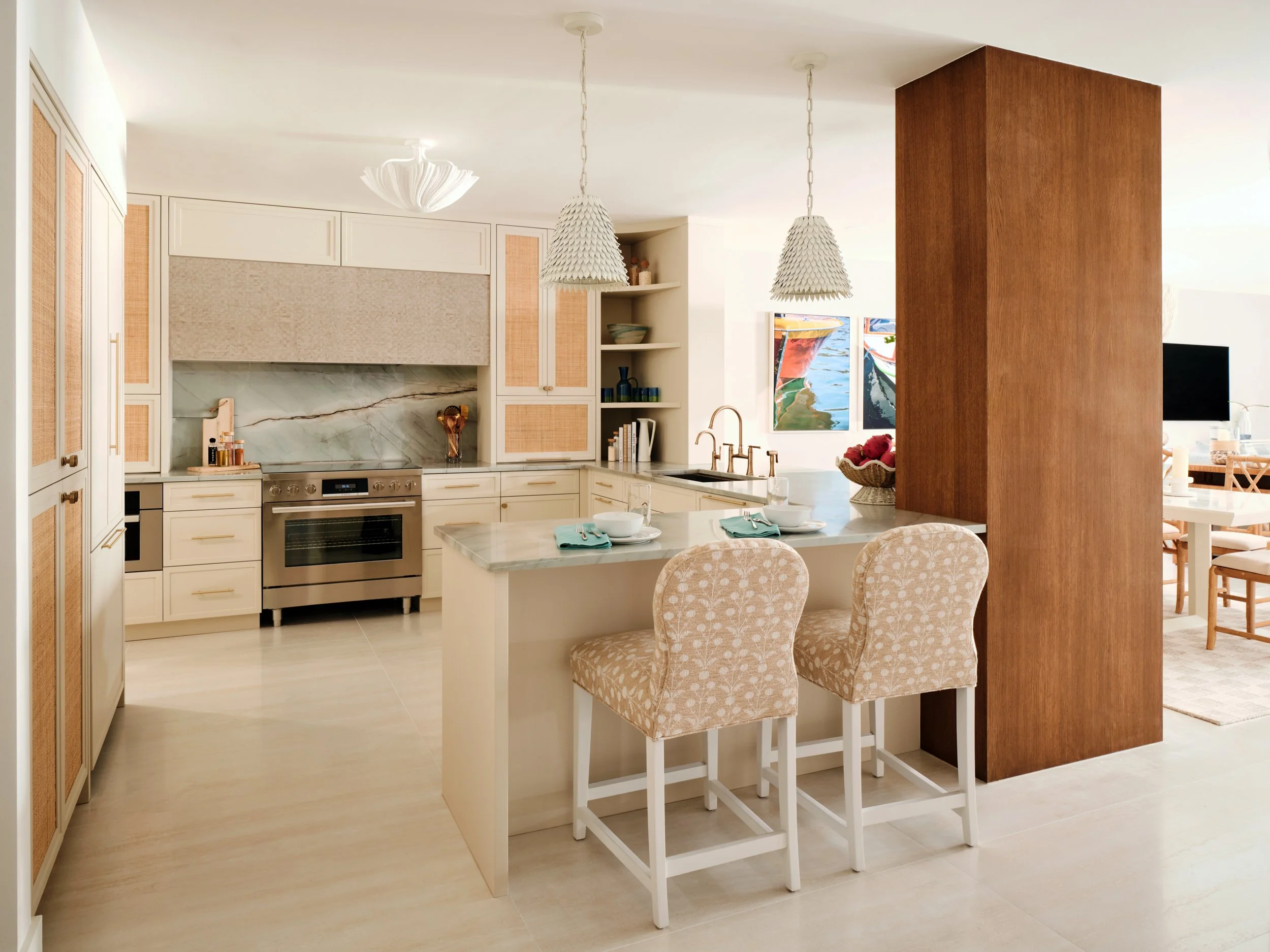 Renovated kitchen at The Duchess on Marco Island with an oak-clad structural column, rattan inset cabinets and shell pendant lights