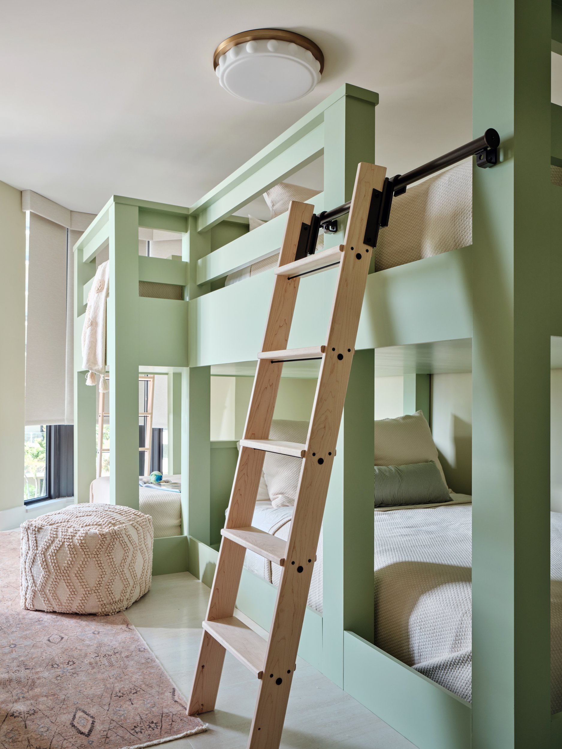 Children’s bunk room at The Duchess on Marco Island with custom sage built-in bunks and a rolling wood ladder