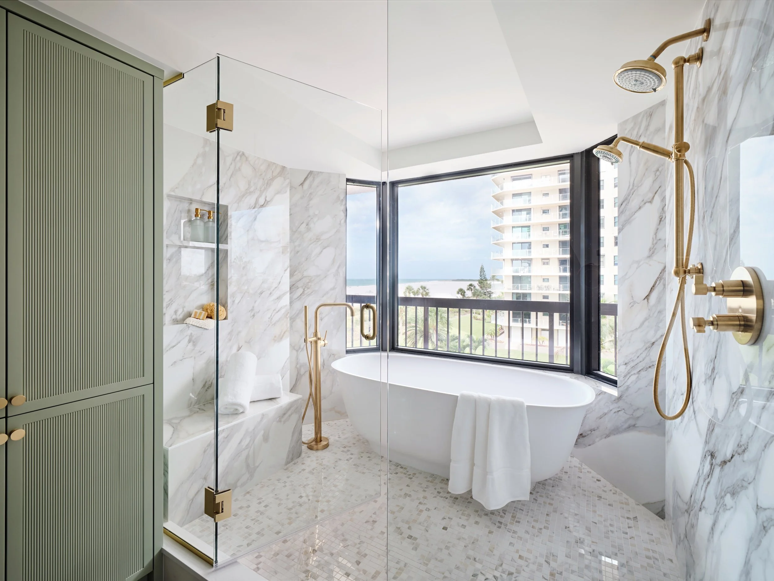 Primary bathroom at The Duchess on Marco Island with a freestanding tub inside a glass wet room and ocean views