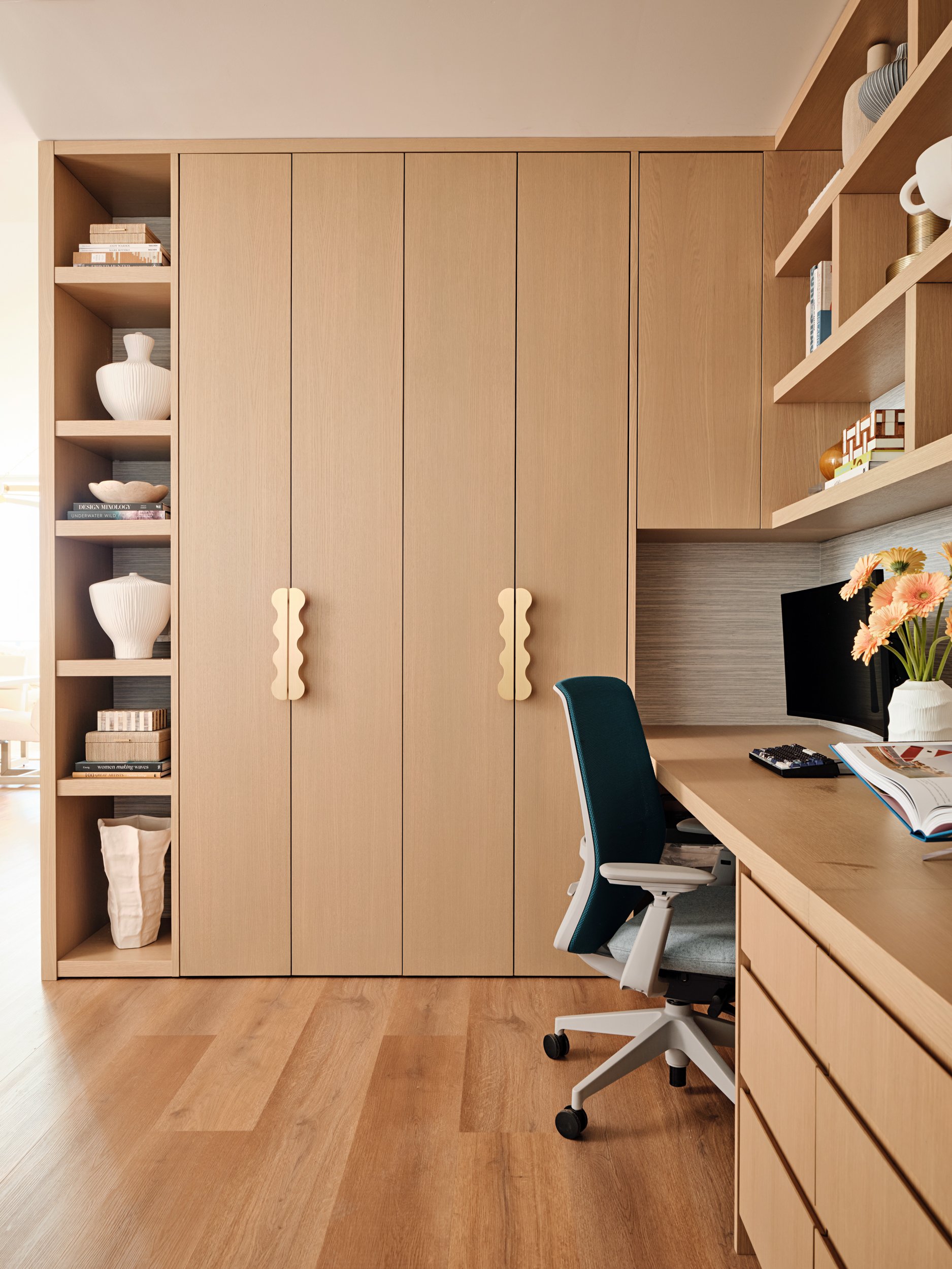 Floor-to-ceiling white oak cabinets with sculpted brass pulls in a custom home office