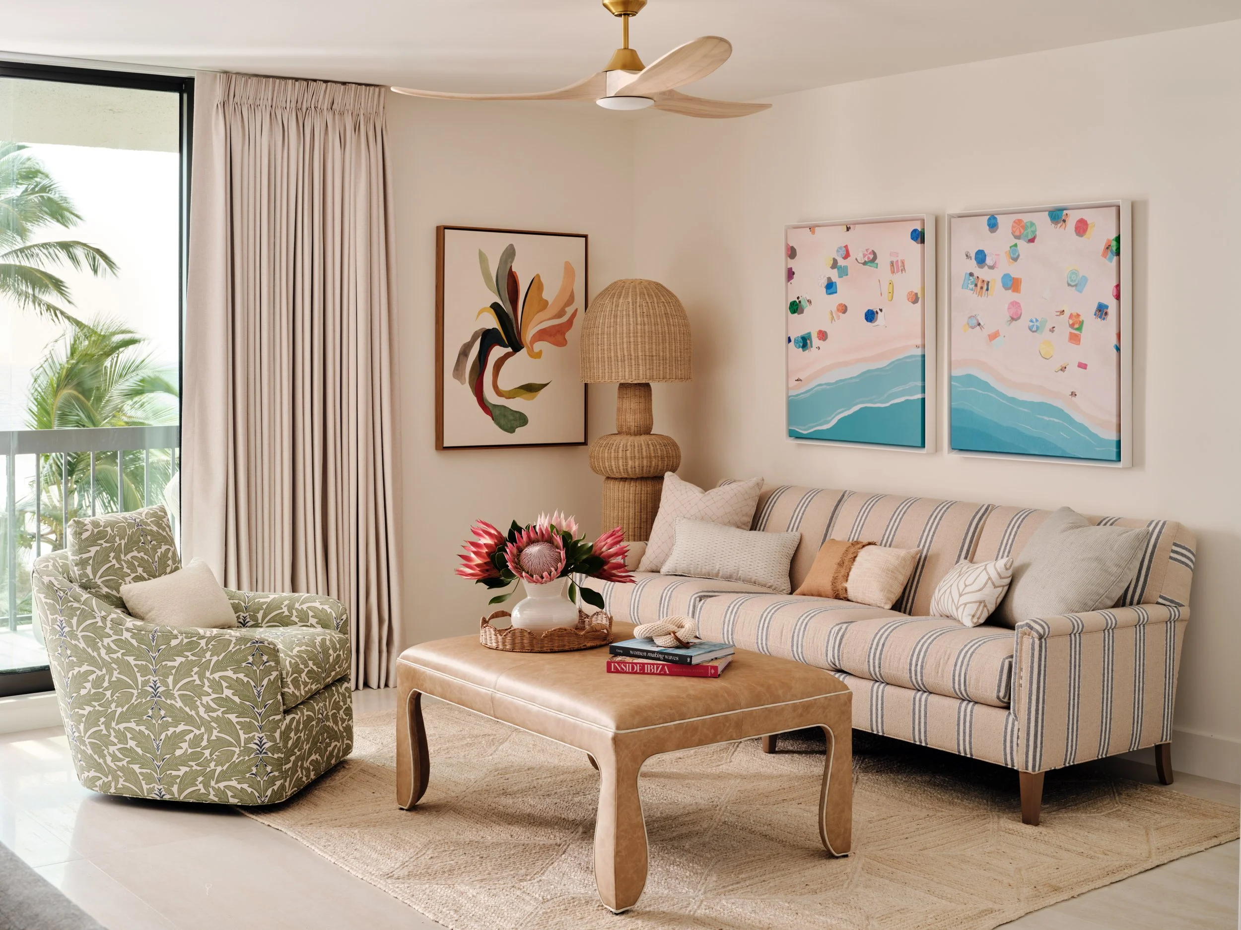 Renovated living room at The Duchess on Marco Island with a striped sofa, botanical-print armchair and leather ottoman coffee table