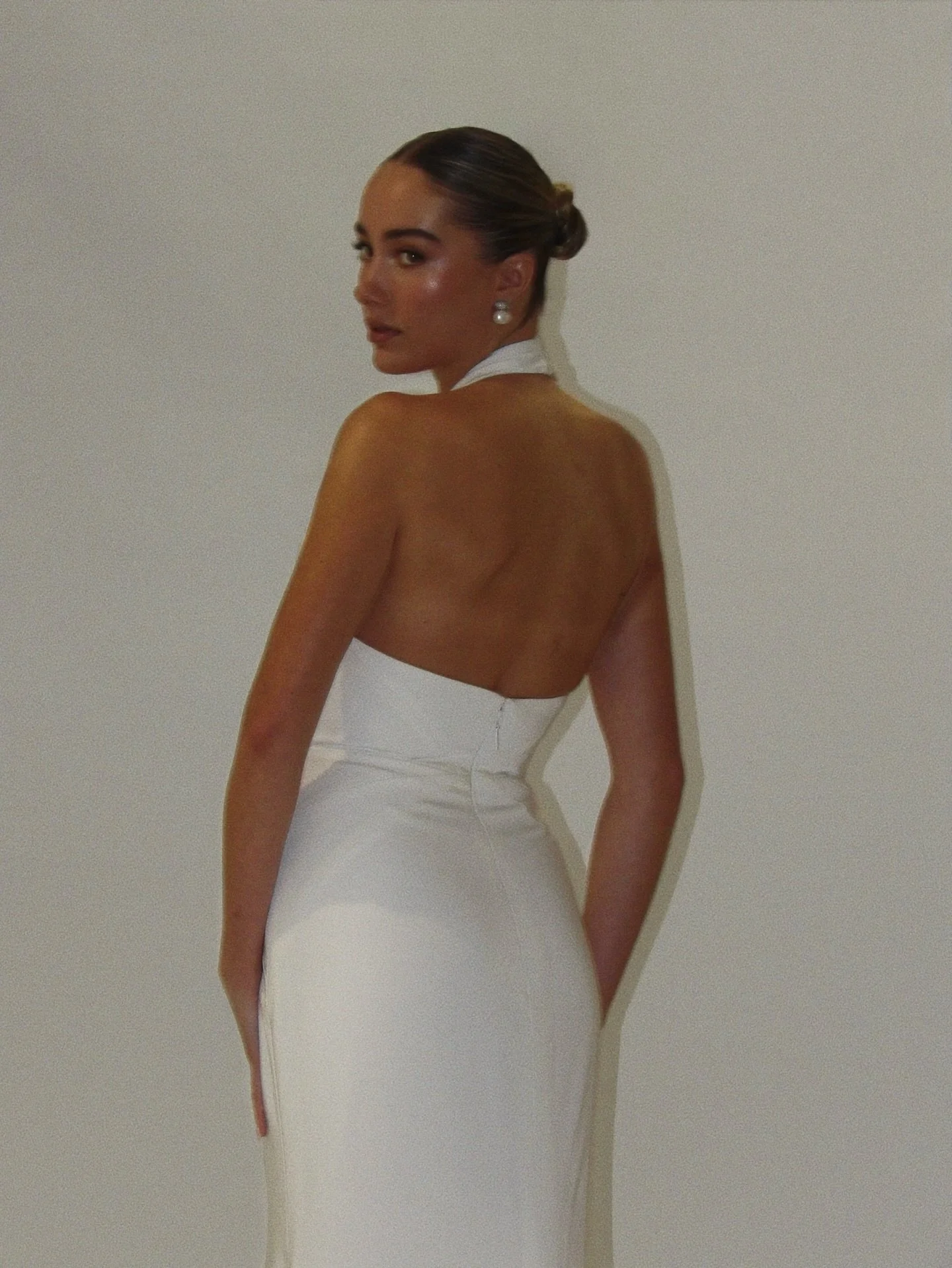 Figure hugging and detail-driven. Design lines create the intricate and refined fit to the Lita Gown with this low back, halter-neck look.