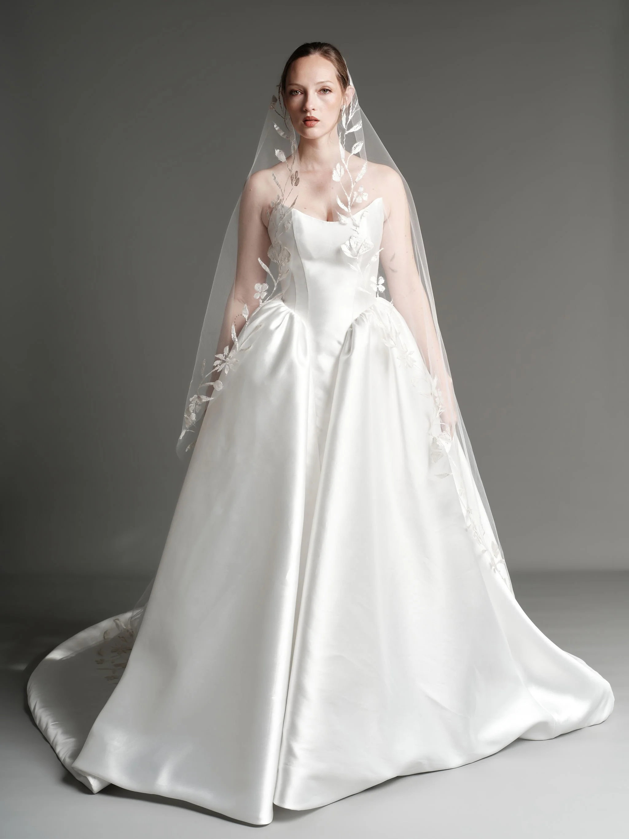 An ethereal pairing for the bride drawn to understated drama and artful detail. The Madeline gown paired with our hand painted botanical veil.