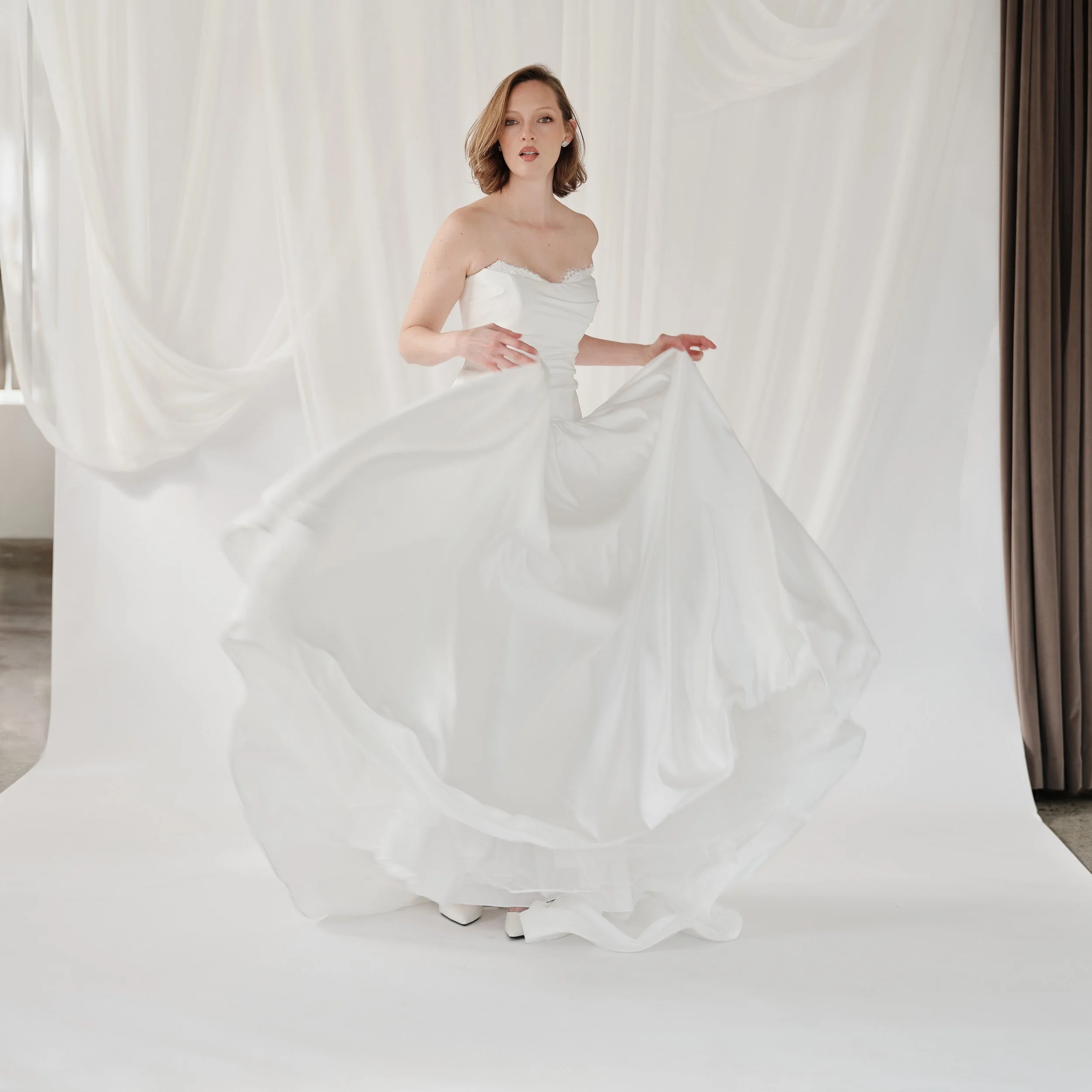 The kind of gown that needs an introduction. Softly draped through the bodice, sculpted through the waist and finished with a skirt made for movement. Modern, effortless and with just enough drama. Introducing Angelique