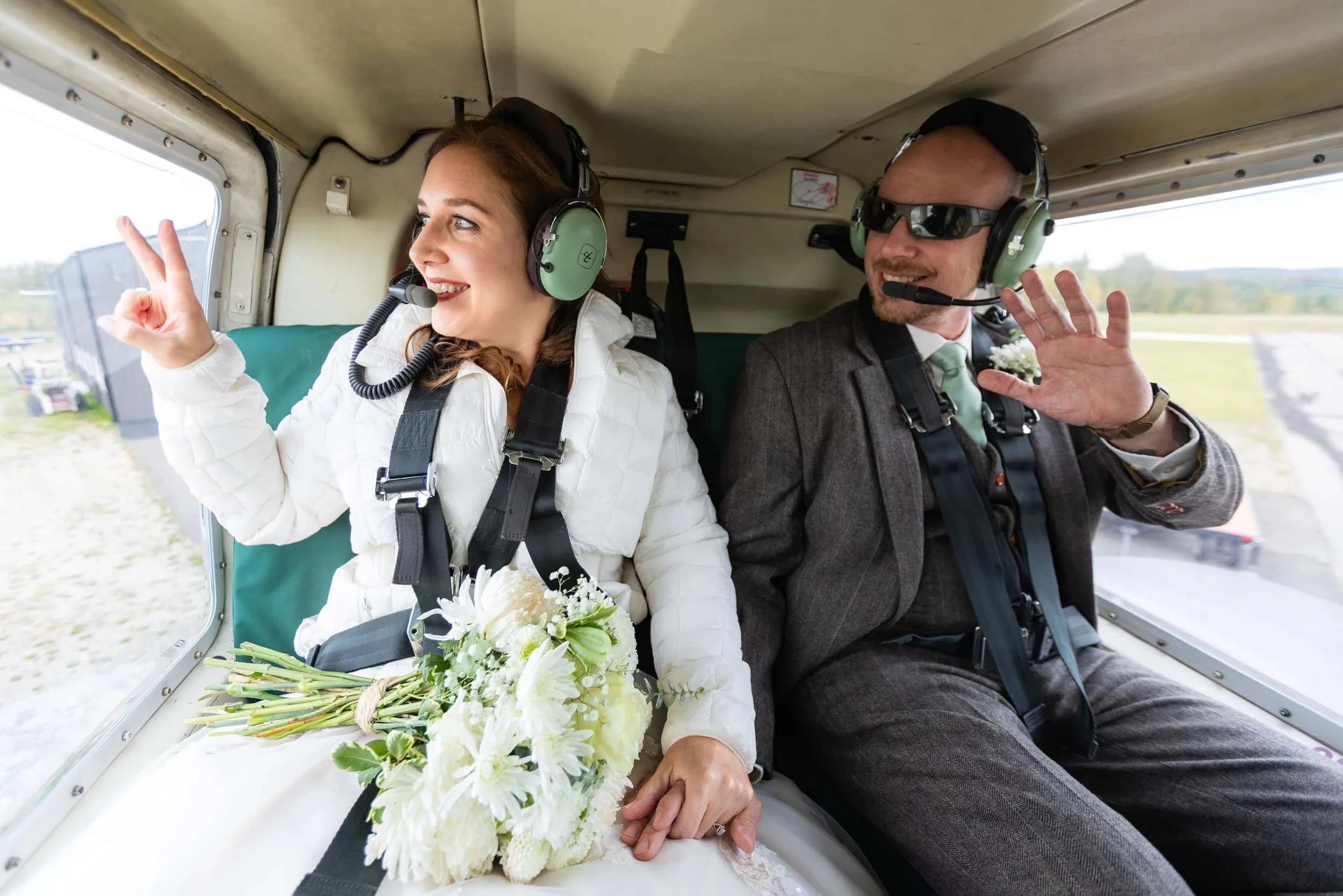 Couple Waving in a helicopter on the way to their Jasper Elopement