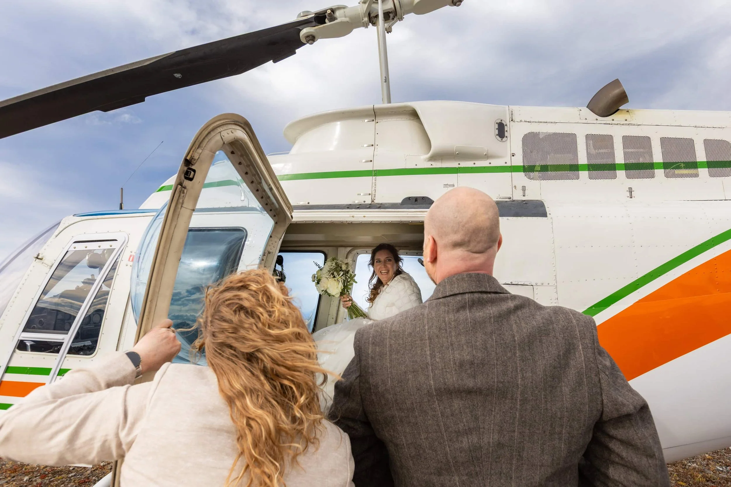 Bride smiling in a helicopter after getting married