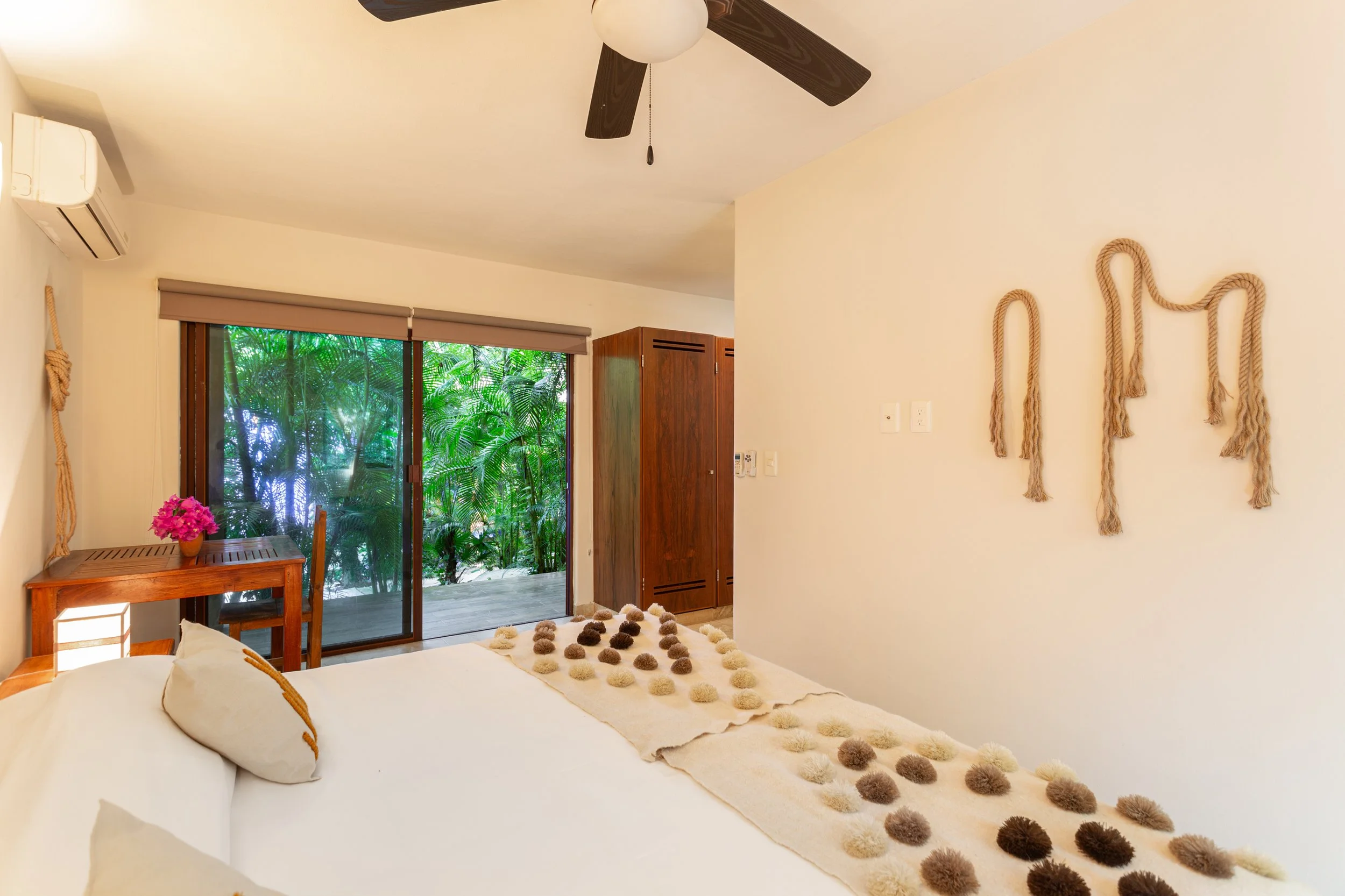 picture of private apartment at dora campus in tulum with a king bed and warm surroundings, depicting calm and healing
