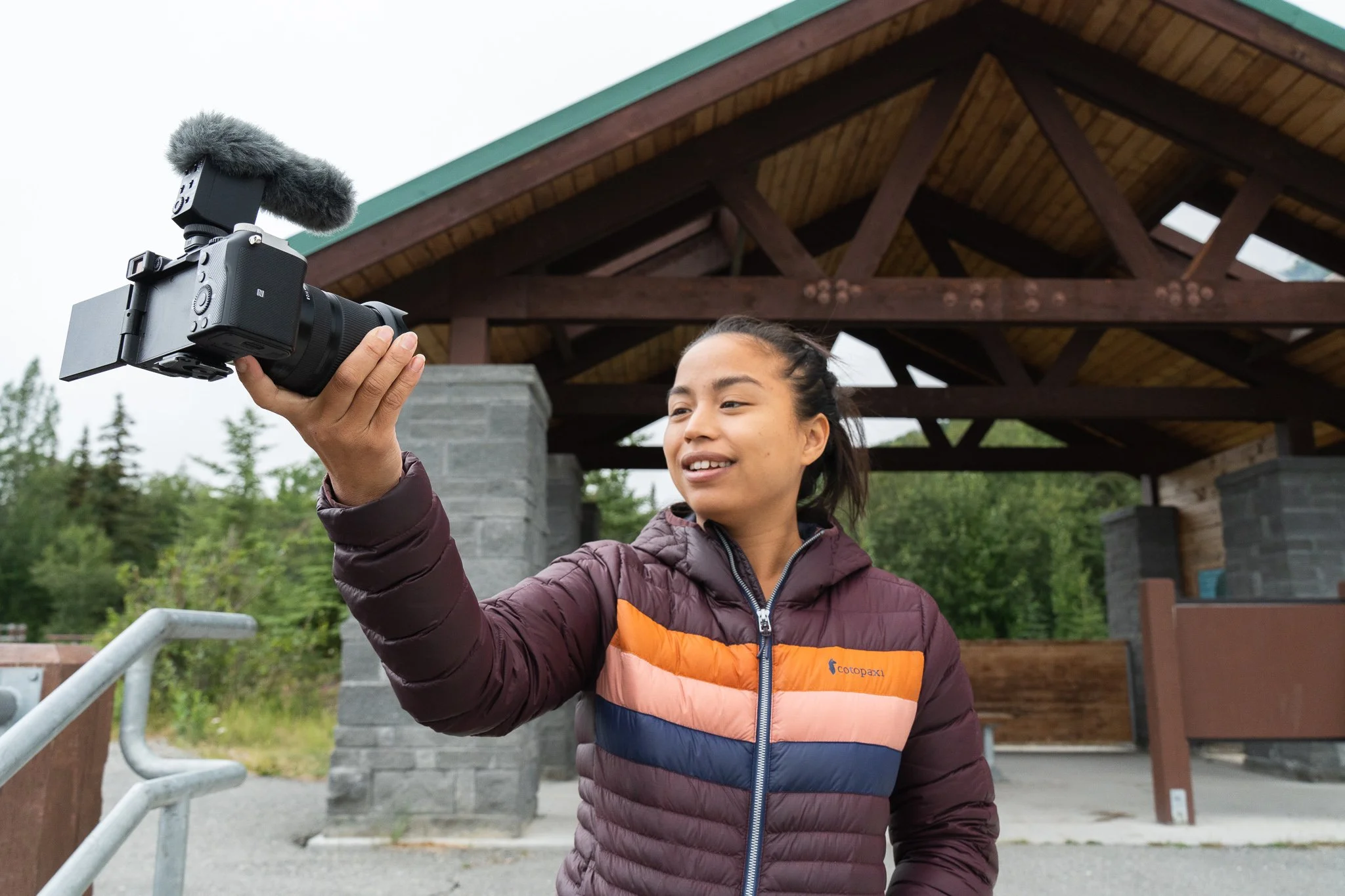 A woman holding a sony camera and vlogging