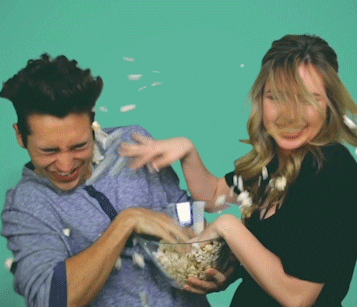 Couple throwing popcorn on each other