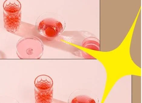Close-up of various red and pink glasses and a bowl filled with a red liquid, on a light pink surface.